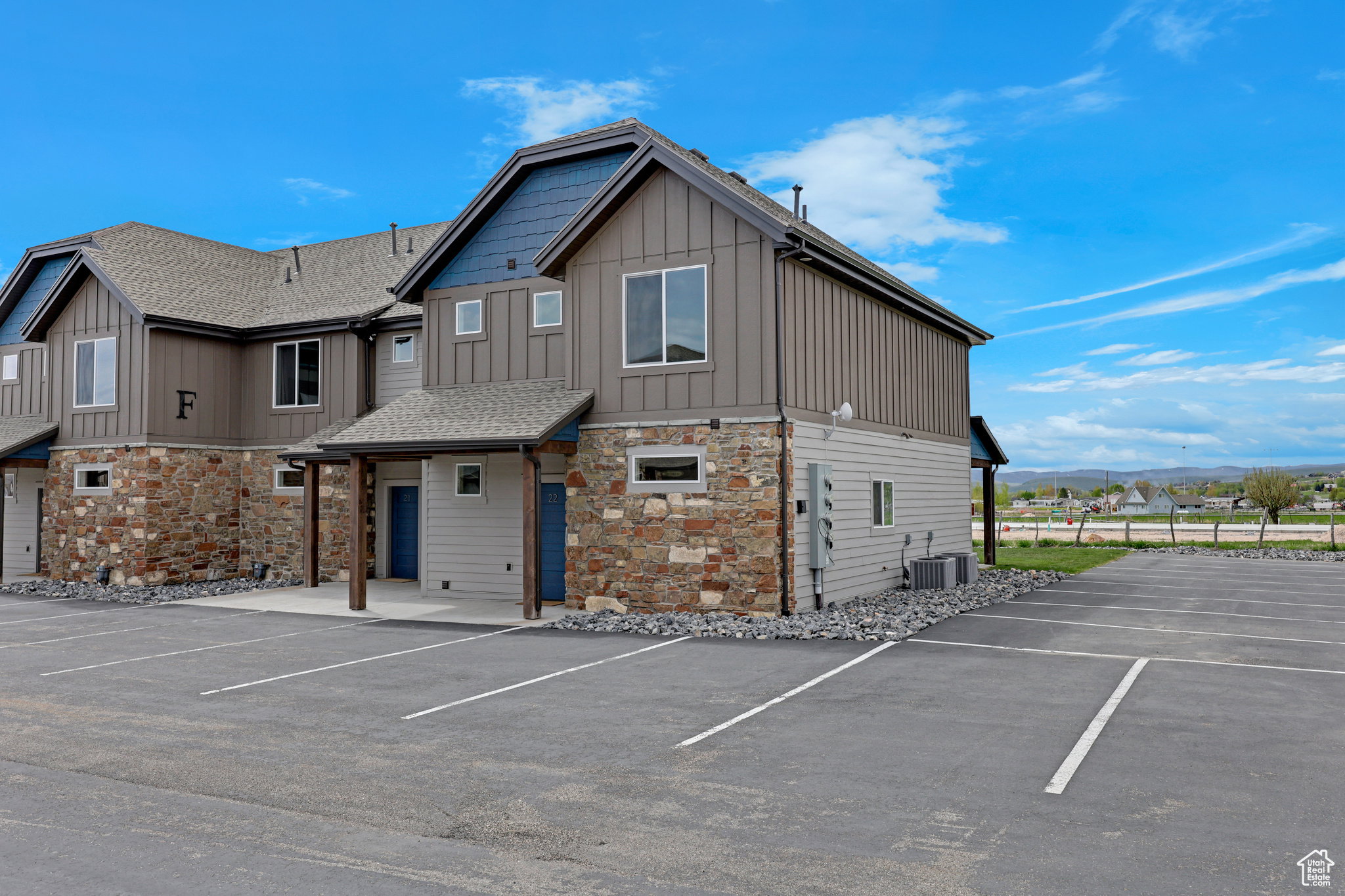 View of building exterior with a mountain view and uncovered parking