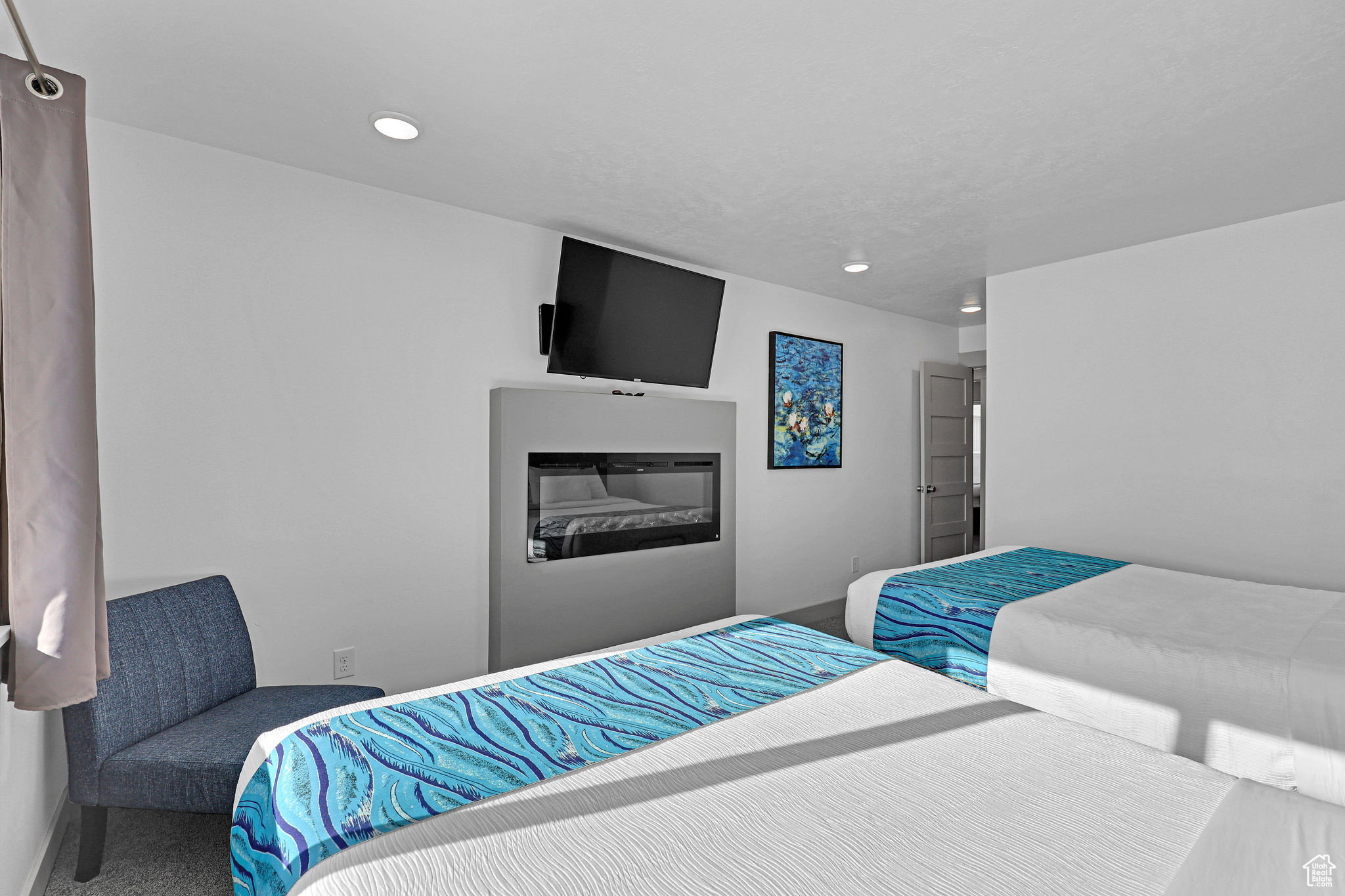 Bedroom featuring carpet and a glass covered fireplace