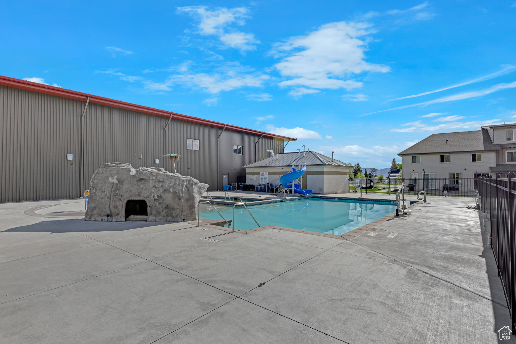Community pool with a patio area and a residential view