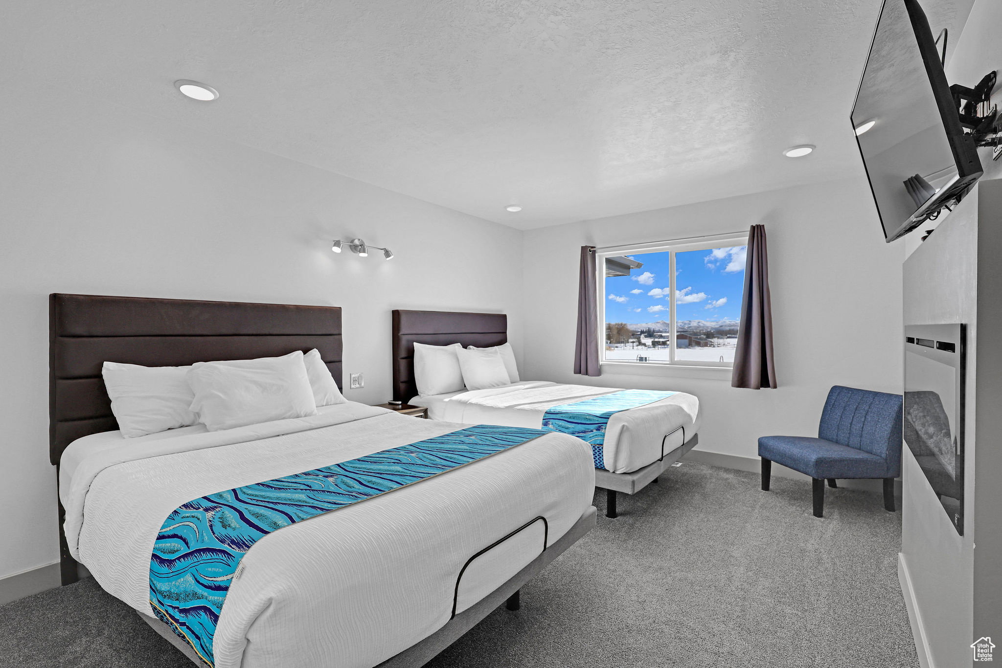 Bedroom featuring light carpet, a fireplace, and a textured ceiling