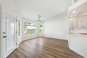 Unfurnished dining area featuring lofted ceiling, light wood-style flooring, and recessed lighting