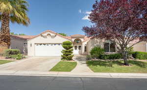 Mediterranean / spanish house featuring a tiled roof, an attached garage, driveway, and stucco siding