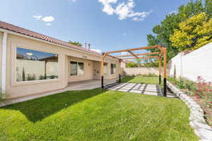 Fenced backyard featuring a pergola and a patio area