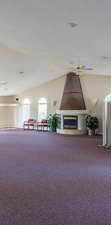 Interior space with a ceiling fan and a large fireplace