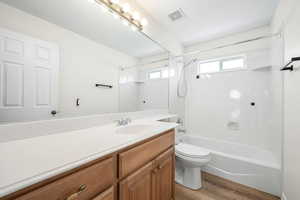 Bathroom featuring vanity, light wood finished floors, and  shower combination