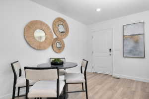 Dining room with light wood-style flooring and recessed lighting