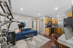 Living area with dark wood finished floors, recessed lighting, and an office area