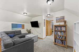 Living room featuring vaulted ceiling and light carpet