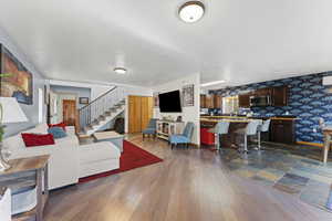 Living area featuring wallpapered walls and dark wood-style flooring