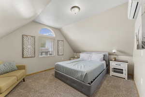 Carpeted bedroom with a mini split for heating / cooling and baseboards