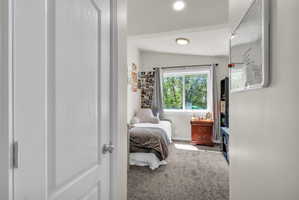 Carpeted bedroom featuring vaulted ceiling and baseboards