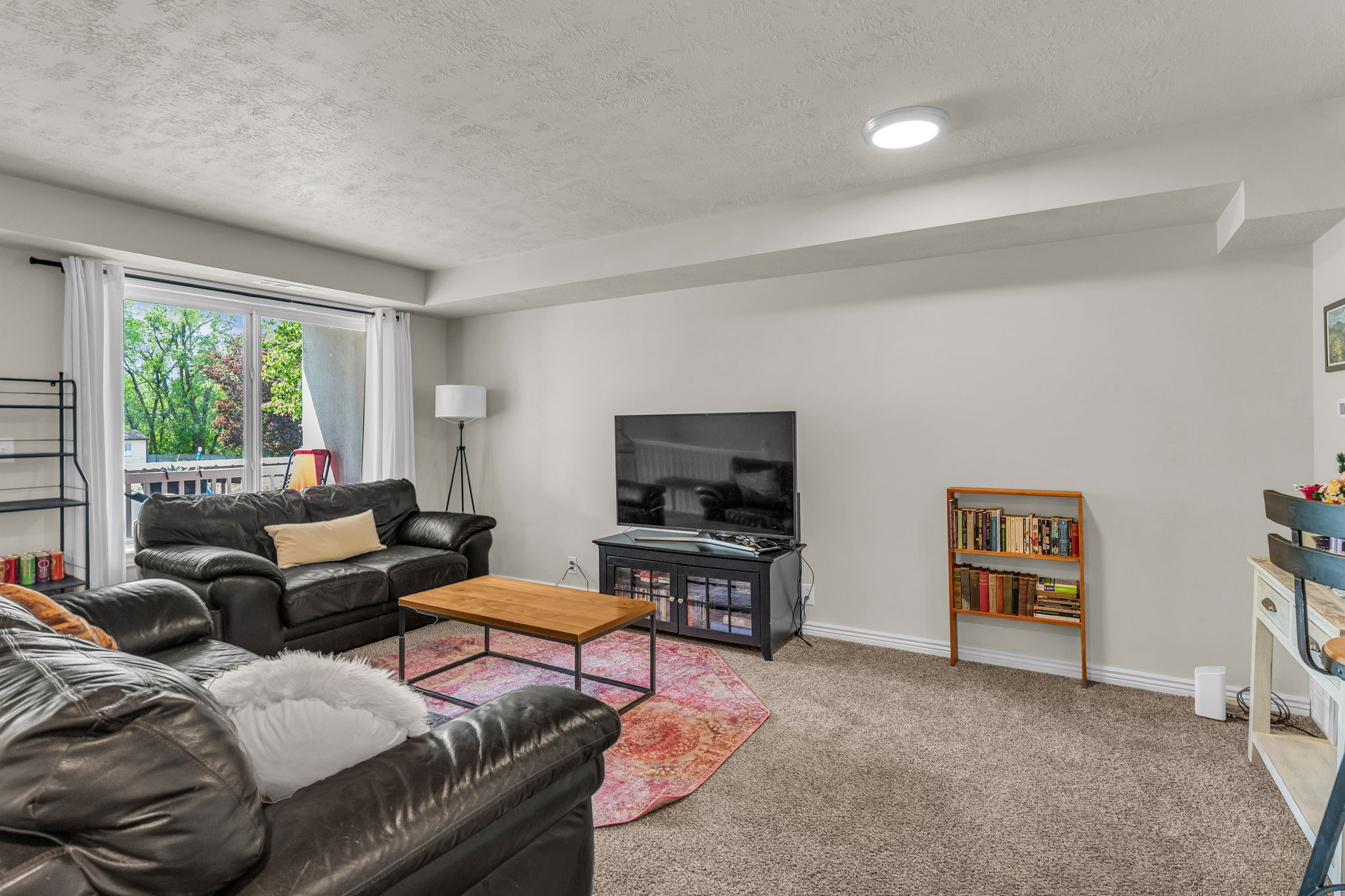 Carpeted living room with a textured ceiling