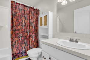 Bathroom featuring vanity and shower / bathtub combination with curtain