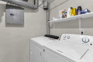 Laundry room with electric panel and washing machine and dryer