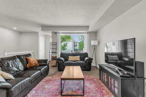 Living room with carpet and a textured ceiling