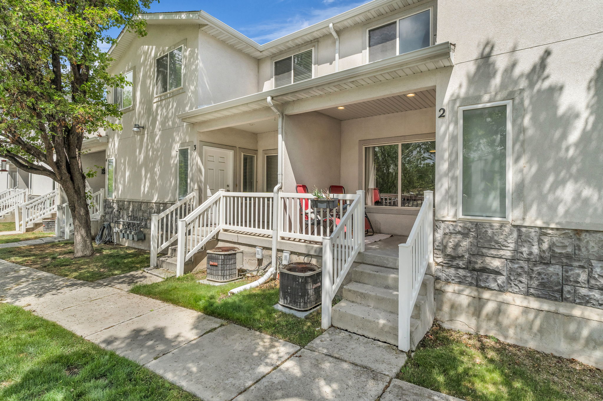 View of front of house with stucco siding, stone siding, and a porch