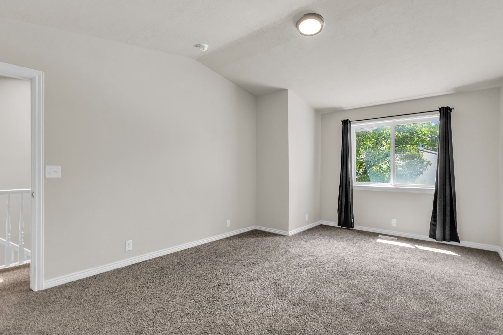 Unfurnished room featuring carpet floors and lofted ceiling