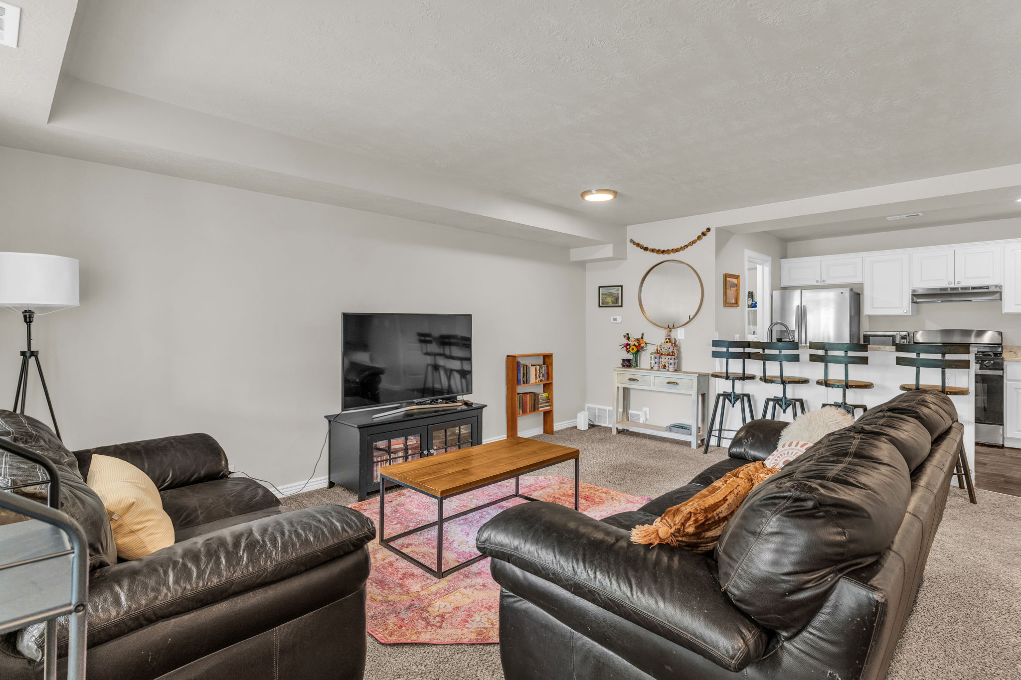 Living area featuring baseboards and light carpet