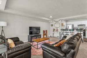 Living area featuring baseboards and light carpet