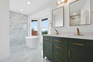 Full bathroom with double vanity, a soaking tub, recessed lighting, a marble finish shower, and light marble finish flooring