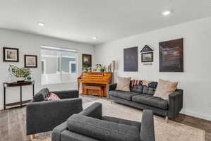 Living room featuring light wood-type flooring, a textured ceiling, and recessed lighting