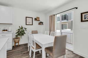 Dining space with baseboards and dark wood-style flooring