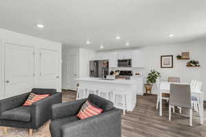 Living area featuring dark wood-style flooring and recessed lighting