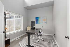 Office space with light colored carpet and baseboards