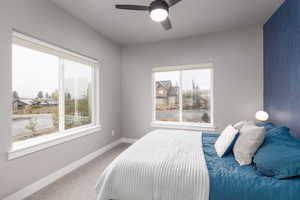 Carpeted bedroom with baseboards and a ceiling fan