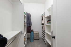 Walk in closet with light colored carpet