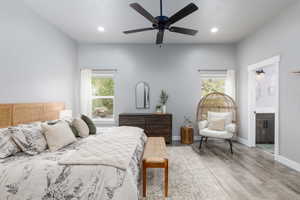 Bedroom with recessed lighting, light wood finished floors, connected bathroom, and ceiling fan