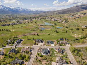 Aerial view of residential area with a golf club and a water and mountain view