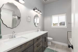 Bathroom featuring double vanity and toilet