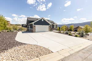 Craftsman house featuring board and batten siding, concrete driveway, a garage, a mountain view, and roof with shingles