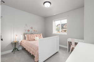 Bedroom featuring light carpet