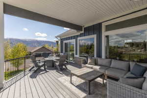 Wooden deck with an outdoor living space with a fire pit and a mountain view