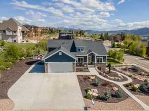 Craftsman-style home with stone siding, board and batten siding, a garage, concrete driveway, and covered porch