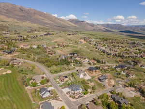 Aerial perspective of suburban area with a mountainous background and a local golf course