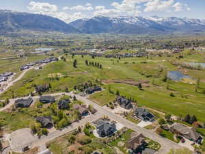 Aerial perspective of suburban area with a water and mountain view and a golf club