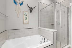 Full bathroom featuring a stall shower and a bath