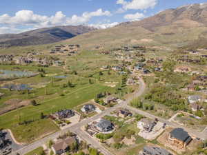 Aerial perspective of suburban area featuring a water and mountain view and a golf course