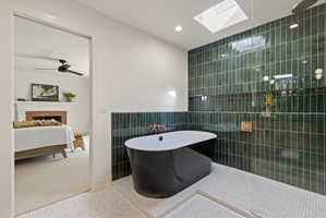 Bathroom featuring tile walls, tile patterned floors, a fireplace, recessed lighting, and a freestanding bath