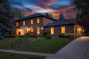 View of front of property featuring brick siding, driveway, a front lawn, and a garage