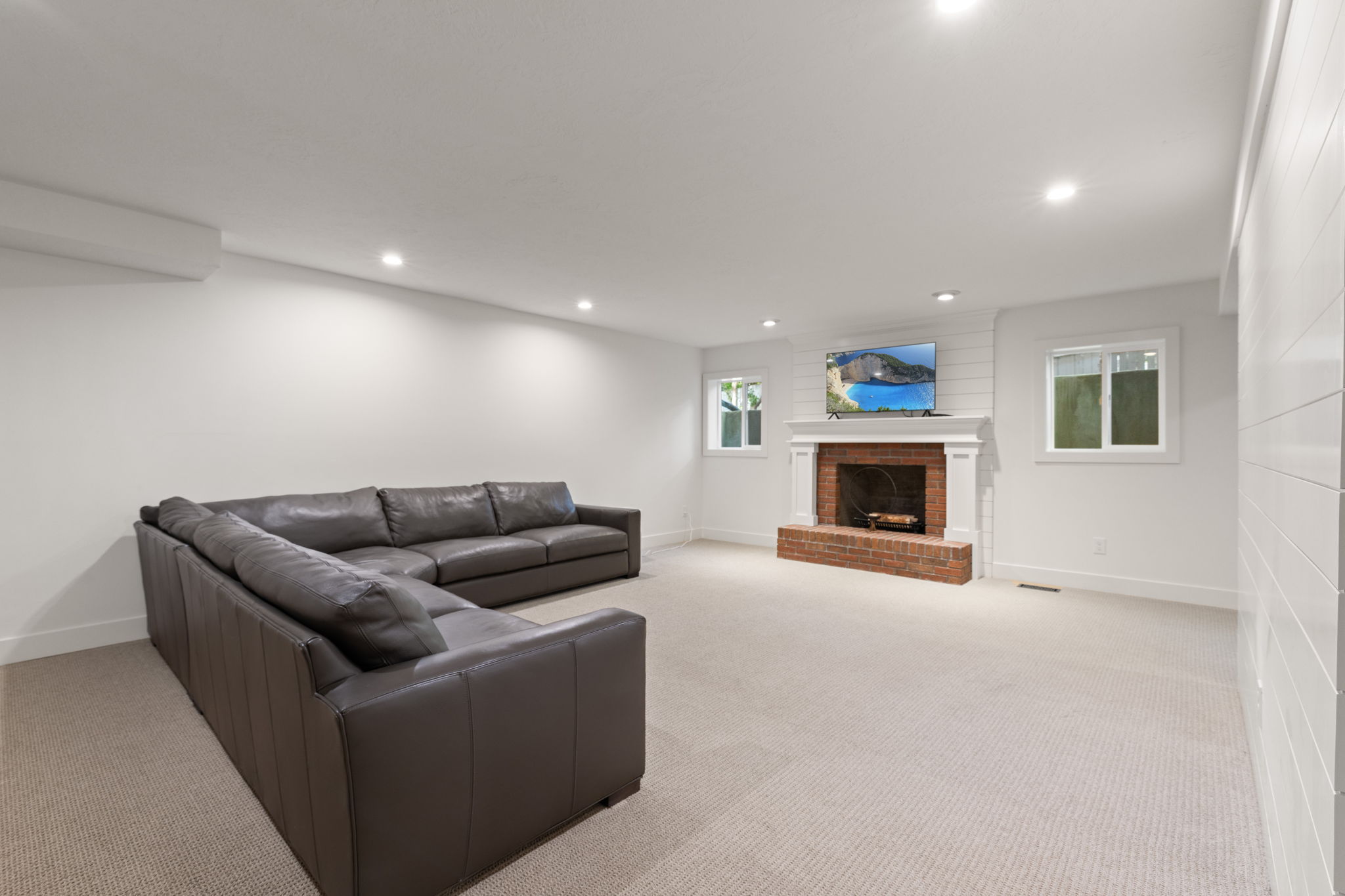 Living room with light carpet, a fireplace, and recessed lighting