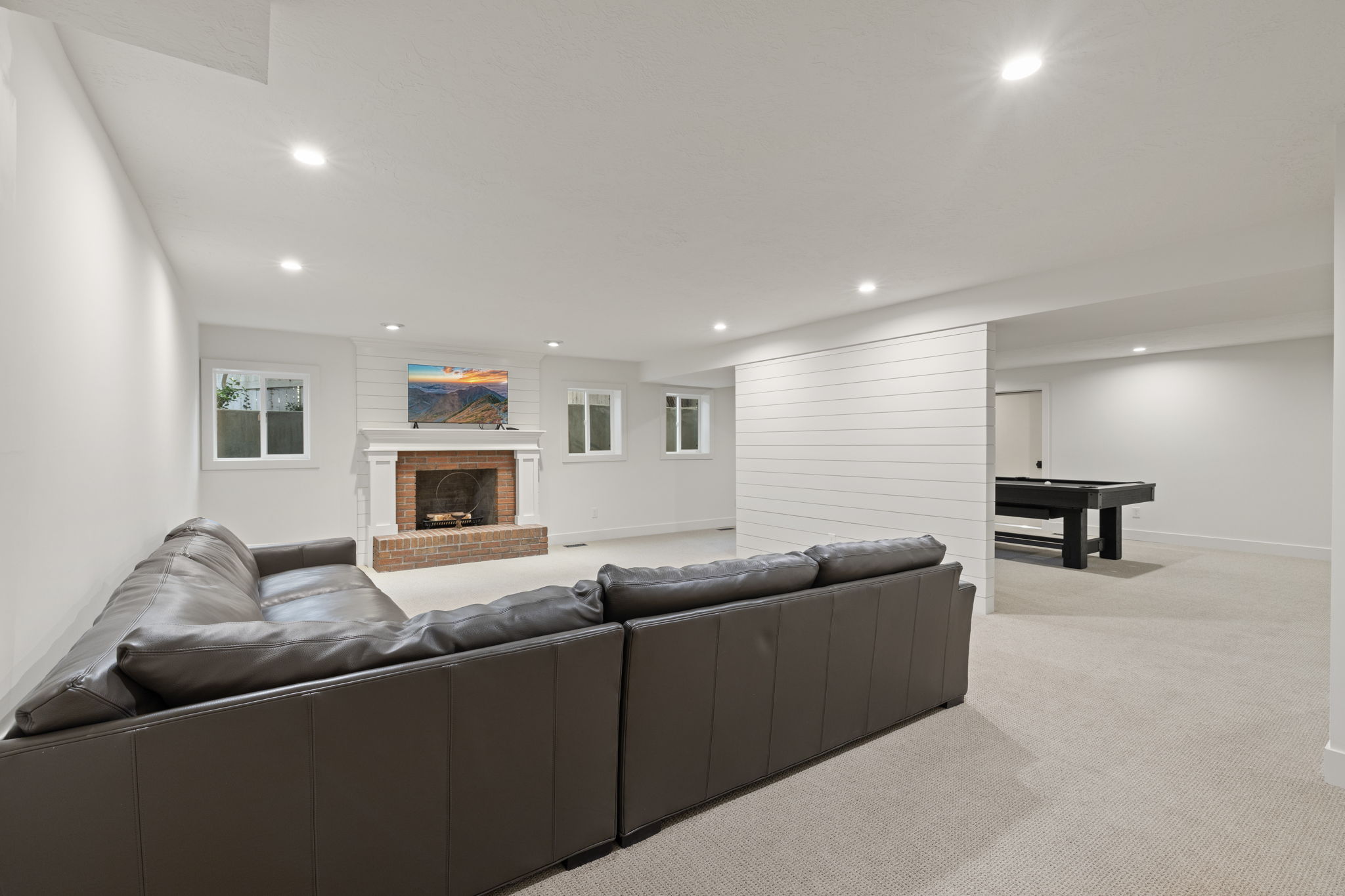 Living room featuring a fireplace, light carpet, and recessed lighting