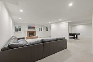 Living room featuring a fireplace, light carpet, and recessed lighting