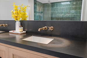 Bathroom view of vanity, backsplash, and walk in shower