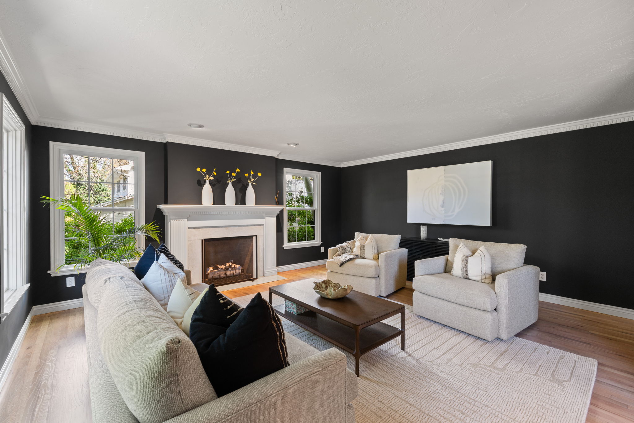 Living area featuring a high end fireplace, light wood-type flooring, and ornamental molding