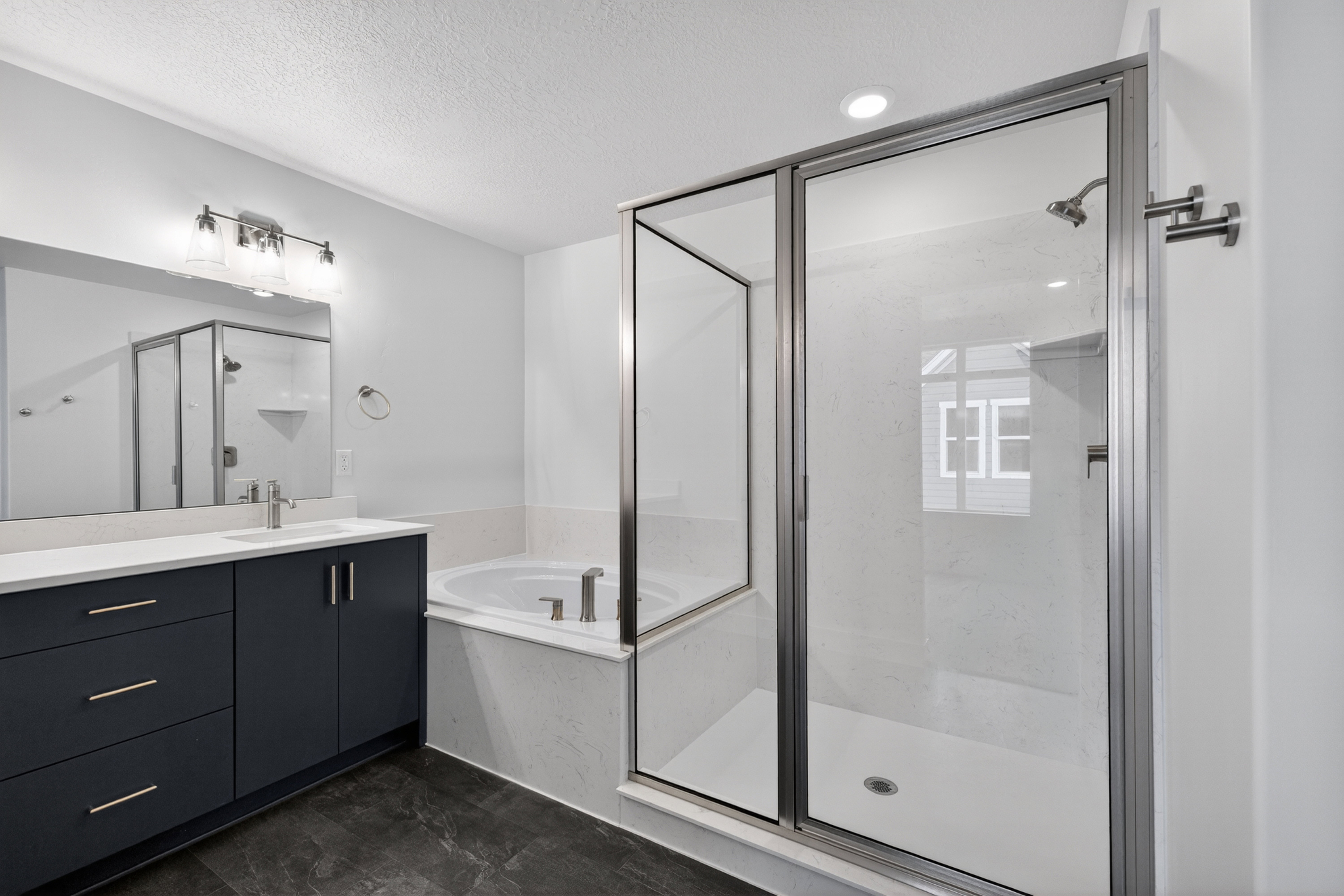 Bathroom with a marble finish shower, vanity, a bath, and a textured ceiling