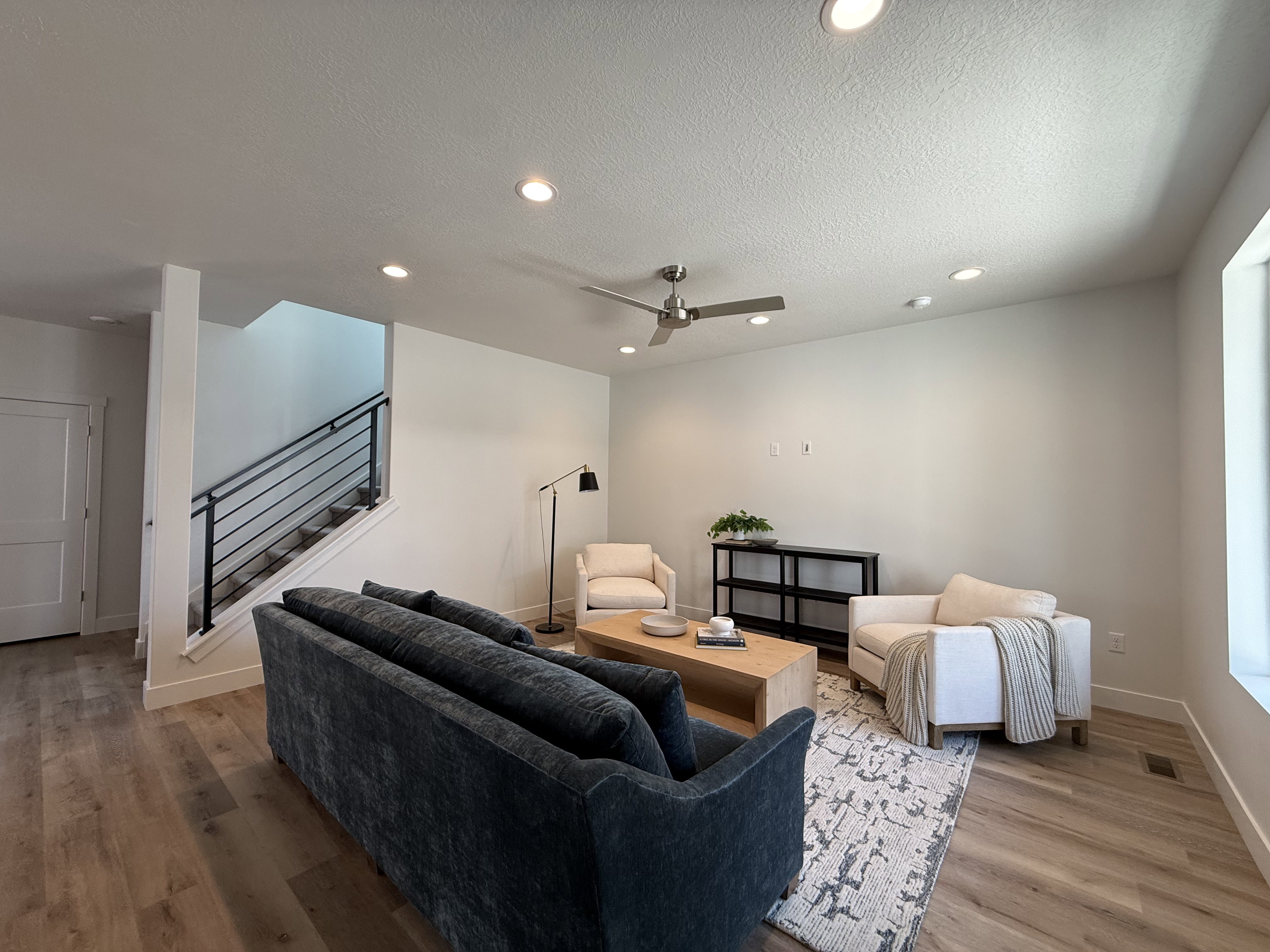Open living area featuring wood-finish flooring, recessed lighting, and a contemporary ceiling fan